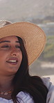 Relax, woman and holiday on beach with hat, tourist sightseeing or reflection for getaway. Female person, summer and thinking by ocean with smile, travel accessory and tropical island for vacation