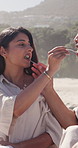 Happy couple, eating and beach with picnic basket for romantic date, love or honeymoon together. Man, woman or relax with feeding or fruit on ocean coast for holiday trip, vacation or valentines day