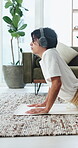 Exercise, headphones and stretching with yoga man in home living room for balance or flexibility. Audio, cobra pose and fitness with Asian person on floor in apartment for health or wellness activity