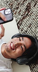 Man, headphones and smile on floor with phone, yoga mat or wellness break to check mobile app for music. Above, Asian person and scroll in home with fitness rest, tech and streaming site for audio.