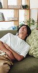 Frustrated, man and sofa with stomach ache for indigestion, diarrhea or constipation in home. Male person, sore tummy or belly pain with gastrointestinal reflux, virus or food poisoning in house