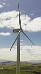Blue sky, development and wind turbine outdoor in nature for production of alternative energy. Clouds, environment and sustainability with aerogenerator in countryside for electricity or power supply