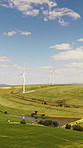 Landscape, field and wind turbine for renewable energy in nature with eco friendly electricity production. Outdoor, horizon and windmill for sustainability, sky and space for power in countryside