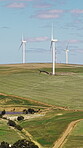 Eco friendly, wind turbine and renewable energy in farm, drone or sustainability with zero emissions. Grass field, windmill and natural resource for carbon footprint in environment, space and outdoor