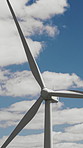 Clouds, development and wind turbine outdoor in nature for production of alternative energy. Blue sky, environment and sustainability with aerogenerator in countryside for electricity or power supply