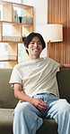 Wellness, face and Asian man on couch with happiness, positive attitude or calm on summer break. Smile, portrait or male person in house with peaceful weekend, free time or good mood in Korea.