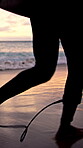 Travel, run and legs at beach with surf board, wave training and sunset hobby on seaside vacation. Holiday activity, jog or person at ocean with gear, water sports or summer evening in Australia.