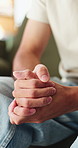 Nervous, man and hands with fear in stress for mental health, PTSD or ADHD on sofa in home. Closeup, male person or patient with pressure, withdrawal or tension for anxiety, panic or trauma in house