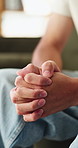 Nervous, man and hands with anxiety or stress for mental health, PTSD or ADHD on sofa in home. Closeup, male person or patient with pressure, withdrawal or tension for fear, panic or trauma in house