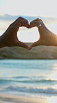 Heart hands, couple and beach for vacation, love for relationship and tropical island for honeymoon. Waves, man and woman with summer holiday for romantic getaway, symbol and emoji sign in Zanzibar