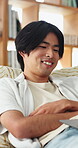 Streaming, laugh or Asian man in home with laptop, movie binging or funny video on online site. Happy, digital or person on sofa with tech, comedy show or series subscription on entertainment app.