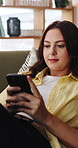 Reading, relax and woman on sofa with phone for online ebook, social media and chat on weekend. Home, comfortable and person on smartphone for connection, digital novel and break on mobile app