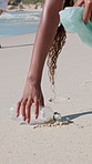 People, plastic or cleaning beach with bag on sand for pollution, dirt or contamination of ecosystem. Volunteer, hands or bottle with rubbish, garbage or litter on ocean coast for waste management