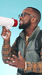 Megaphone, hiker and black man in studio, speaking and communication on blue background. Bullhorn, tourism or person with travel announcement, speech for opportunity or promotion for camping or voice