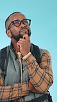 Hiking, thinking and black man in studio with backpack, idea or smile for travel adventure decision. Happy, person and reflection for choice, options or solution for trekking trip on blue background.