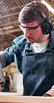 Man, sawing and carpentry machine in workshop for cutting wood, timber design and manufacturing. Male person, ppe gear or electric equipment for woodworking, measure hardwood and furniture production