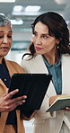 Advice, women and tablet with notebook in office for budget tips, investment support and teamwork. Flare, financial advisor and mature mentor with tech for insurance guidance, finance notes and CRM