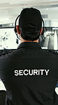 Man, security and agent with headset for surveillance or protection service in control room. Back view, male person or body guard with footage for neighborhood watch, tactical response or safety