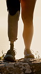 Hiking, mountain and feet of hiker with prosthetic leg for adventure, exercise and cardio workout. Nature, morning and person with disability for wellness, health and fitness for journey or travel