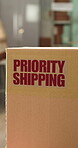Logistics, package and priority shipping label in office, parcel distribution and rush order delivery. Space, supply chain and box with express sticker to streamline transport, startup and freight