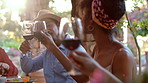 People, friends and cheers with red wine in backyard for support, celebration and reunion dinner. Bokeh, man and woman toast with alcohol at gathering, hangout and gratitude of Easter holiday in home