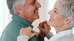 Dancing, happy and old couple in home with holding hands, love or bonding together for anniversary. Music, senior people and hug in house with retirement, support or romantic for marriage commitment.