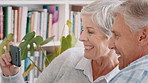 Senior, happy couple and phone with video call in home for conversation or discussion. Elderly, man and woman with smile on mobile smartphone for virtual chat, communication or news together in house
