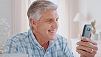 Phone, speaking and old man with video call in home, virtual contact and wave for digital communication. Hello, connection and senior person with smile for conversation, mobile app and talking online