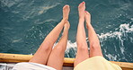 Legs, water and woman friends on boat together for adventure, journey or ocean travel pov. Above, relax and swinging feet with playful people outdoor on yacht for holiday, trip or vacation at sea