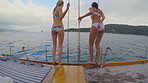 Friends, women and boat for jump in ocean, travel holiday activity and tropical adventure for bonding trip. Slip, back and people on yacht for vacation fun, spring break and swimming in sea together