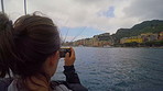 Woman, boat and sightseeing with island picture on sea water for capture moment or vacation memory. Female person, traveler or photography on ship pier for ocean trip, holiday or tourist adventure