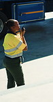 Black woman, talking and logistics with radio outdoor for storage, loading truck and dispatch control. Person, clipboard and guidance for cargo coordination, delivery management and safety compliance