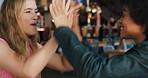 Happy women, high five and catch with food in cafe for competition, winning or bonding together. Female people, friends or smile with throw, feeding or eating trick for good job at indoor restaurant
