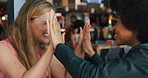Happy women, high five and playing with food in cafe for competition, goofy or bonding together. Female people, friends or smile with throw, feeding or eating for good catch at indoor restaurant