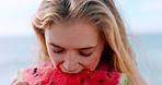 Outdoor, woman and eating watermelon by beach with summer holiday, wind and juicy for delicious taste. Hungry, person and bite sweet fruit by ocean with healthy diet, wellness and snack for vacation.