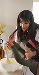 Mother, girl or mix with bowl in kitchen, learn cooking skills or check batter consistency for meal prep. Instructions, happy woman or child with help for baking, bonding or teaching in family home
