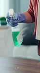 Person, hands and cleaning with spray bottle for housekeeping, hygiene or disinfection in home. Cleaner, detergent or wiping wooden surface with cloth for bacteria, germs or dirt removal in house
