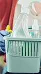 Cleaning, basket and hands of woman in home for chemicals, sanitary tools and bacteria prevention. Spray, housekeeping and disinfection product with person in apartment for equipment and supplies