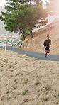 Athlete, man and running for fitness on mountain with exercise, endurance training and cardio. Aerial, male person or runner sprint in nature for sports workout, physical activity and speed challenge
