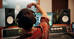 Recording, producer and talking to artist in studio for visual cue, directing performance or music. Back, headphones and man with signal to musician for song composition, audio engineering and timing