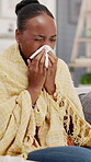 Sick, woman and blowing nose in house with tissue, health problem and flu symptoms from burnout. Blanket, black person and allergy in home with toilet paper, virus or congestion from sinus infection.