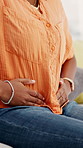 Woman, hands and massage on sofa with stomach ache, menstruation cramps or discomfort from indigestion. Sick, female person and abdomen pain in home with period cycle, health issue or medical crisis.