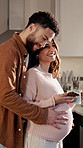 Hug, man and pregnant woman in kitchen, smartphone for social media and online chatting. Couple, pregnancy and people in home, smile and cellphone to track growth, love and support maternity health