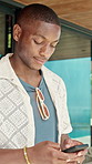 Black man, typing and chatting with phone in resort for communication or network reception. Male person, travel or texting on mobile smartphone or app for social media or online conversation in hotel