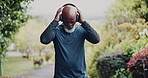 Outdoor, running and senior man with headphones for fitness, cardio workout and streaming music playlist. Park, endurance training and black person with tech for radio, retirement health and exercise
