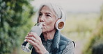 Fitness, headphones and old woman drinking water at park for exercise break, hydration or music. Active, retirement or senior person with liquid for workout rest, thirst or cardio recovery with radio