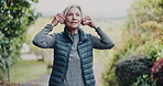 Outdoor, phone or old woman running with headphones for fitness, cardio workout or streaming music album. Park, endurance training and senior person listening with tech for radio, smile and exercise