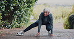 Stretching, outdoor and old woman with exercise, headphones for audio and workout. Runner, bend or mature person with wellness, fitness for health benefits and listen to radio, sound and training