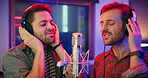Microphone, singing and men in studio with headphones for recording music, song or album. Musicians, creative talent and people for production of audio track together in sound booth in collaboration.