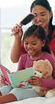 Hairbrush, mother and reading book with child in bedroom, morning routine and childcare for connection. Bonding, happy woman and girl with hair care for grooming, home and fairytale for learning